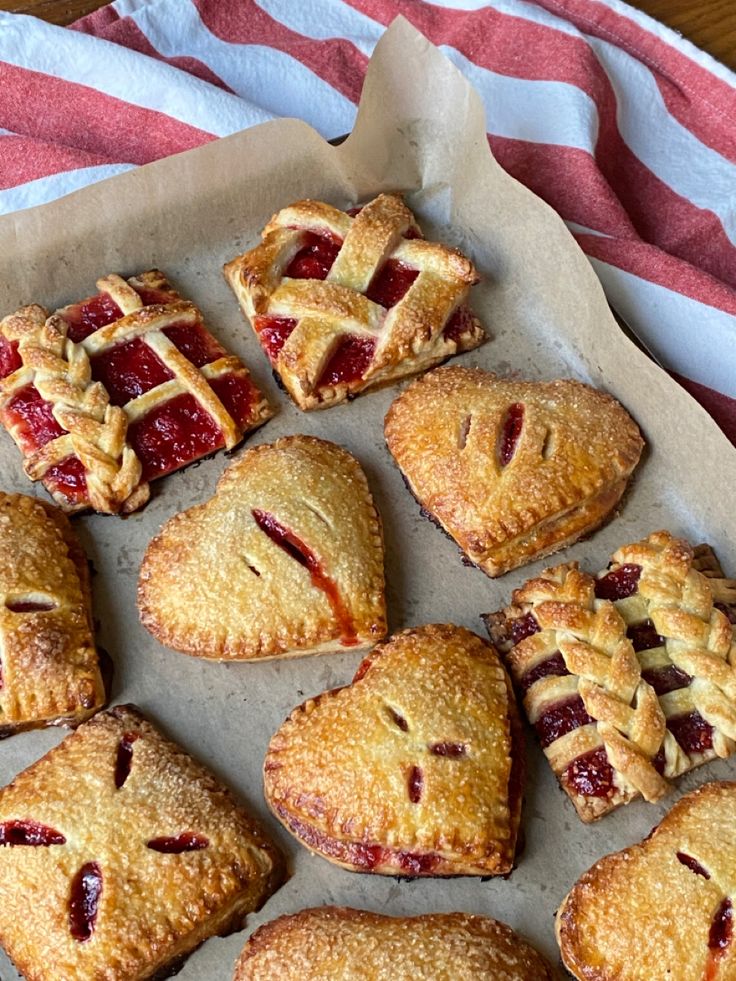 several pies and pastries are arranged on a baking sheet with a striped towel