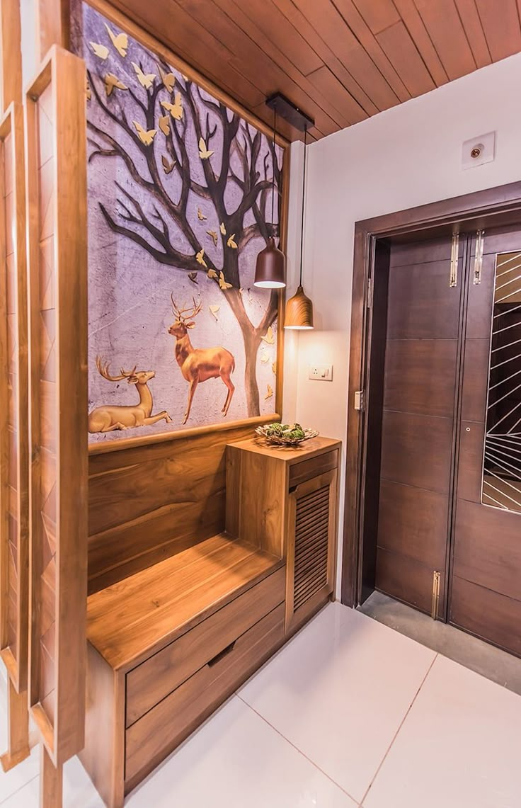 the entryway is decorated with deer and tree paintings on the wall, along with two wooden benches