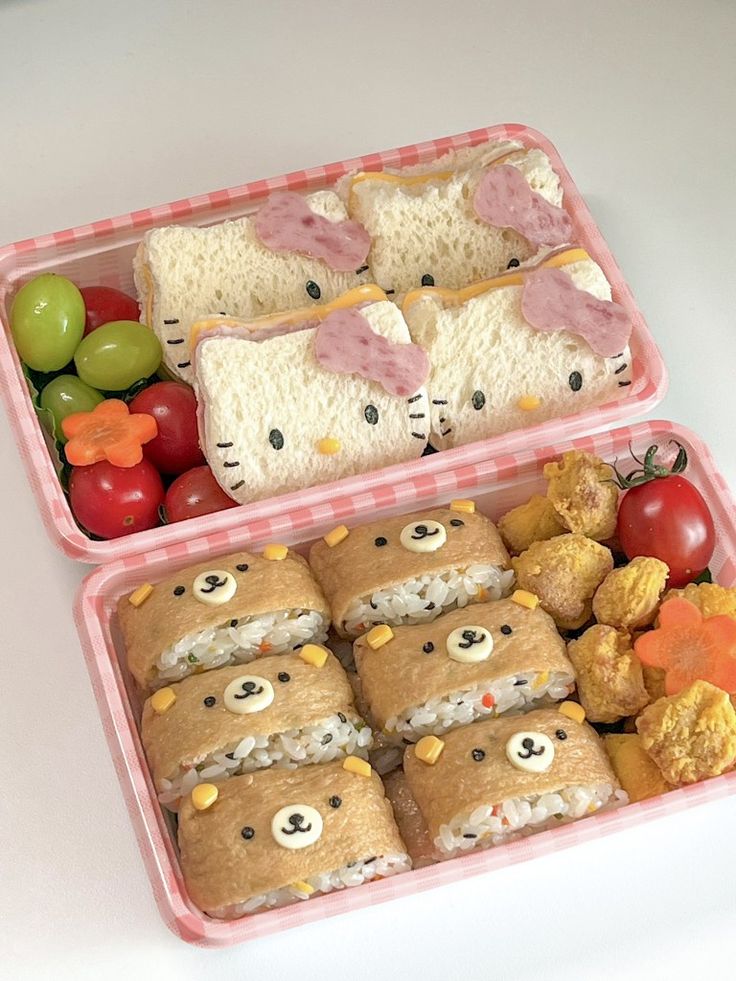 two pink trays filled with food on top of a white table next to each other