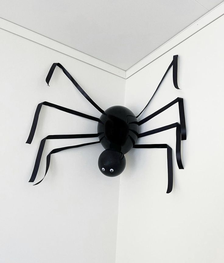 a black spider clock mounted to the side of a wall