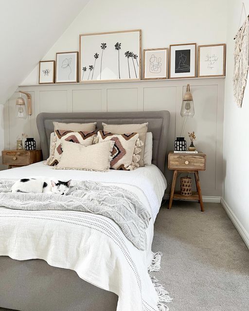 a bedroom with a bed, nightstands and pictures on the wall