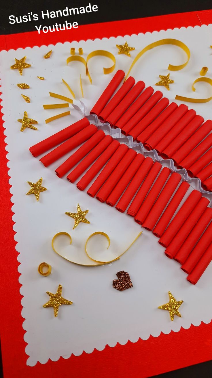 red candles are arranged on a white card with gold stars and glitters around them