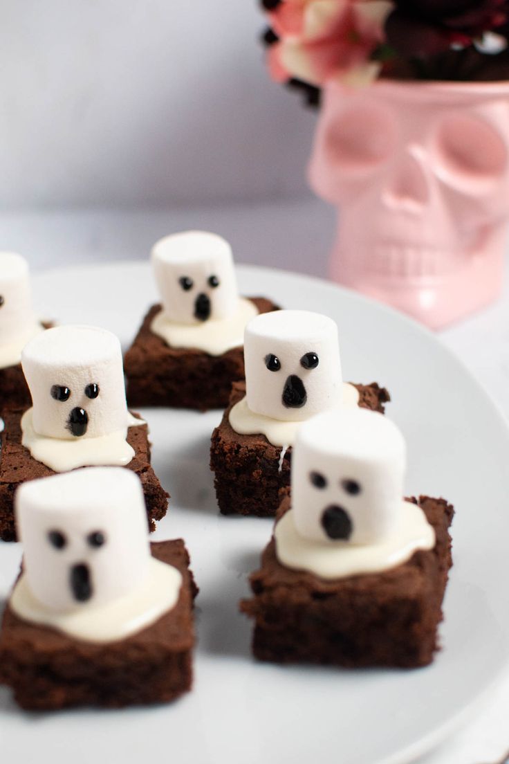 there are brownies with marshmallows and ghost faces on them sitting on a plate