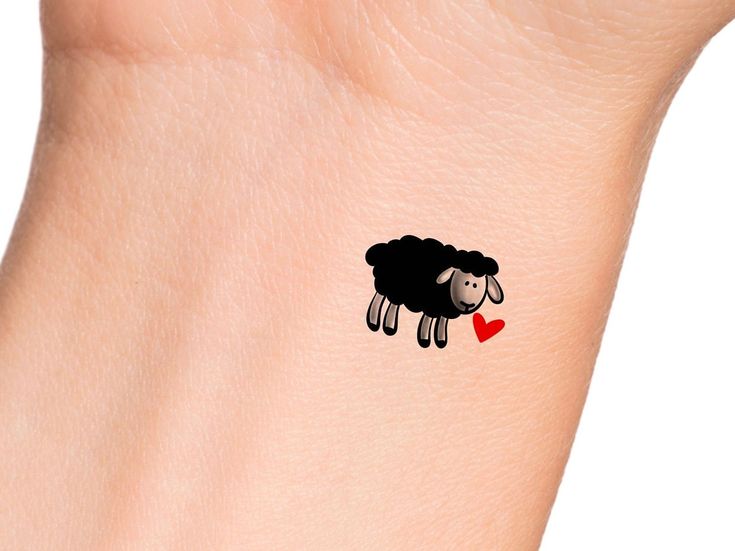 a black sheep with a red heart tattoo on the wrist