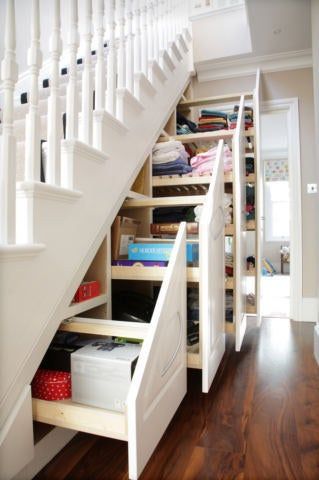 an under the stairs storage area with drawers and shelves underneath it, along with other items