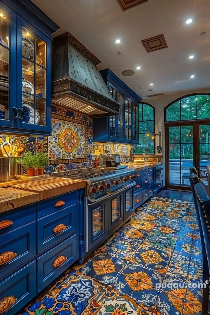 a kitchen with blue cabinets and tile flooring in the center, along with an intricately designed countertop