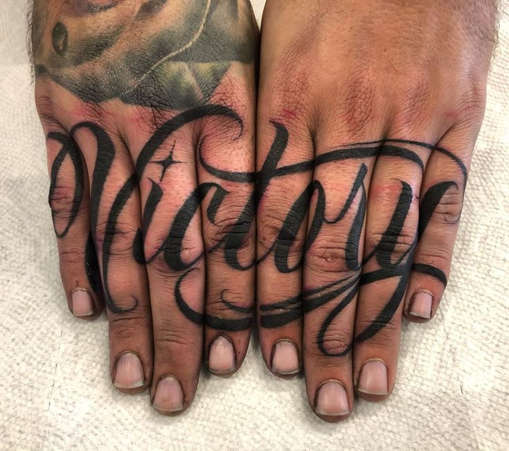 two hands with tattoos on them and the word tattoo written in cursive writing