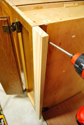 an electric drill is being used to attach the cabinet door frame and screwdriver