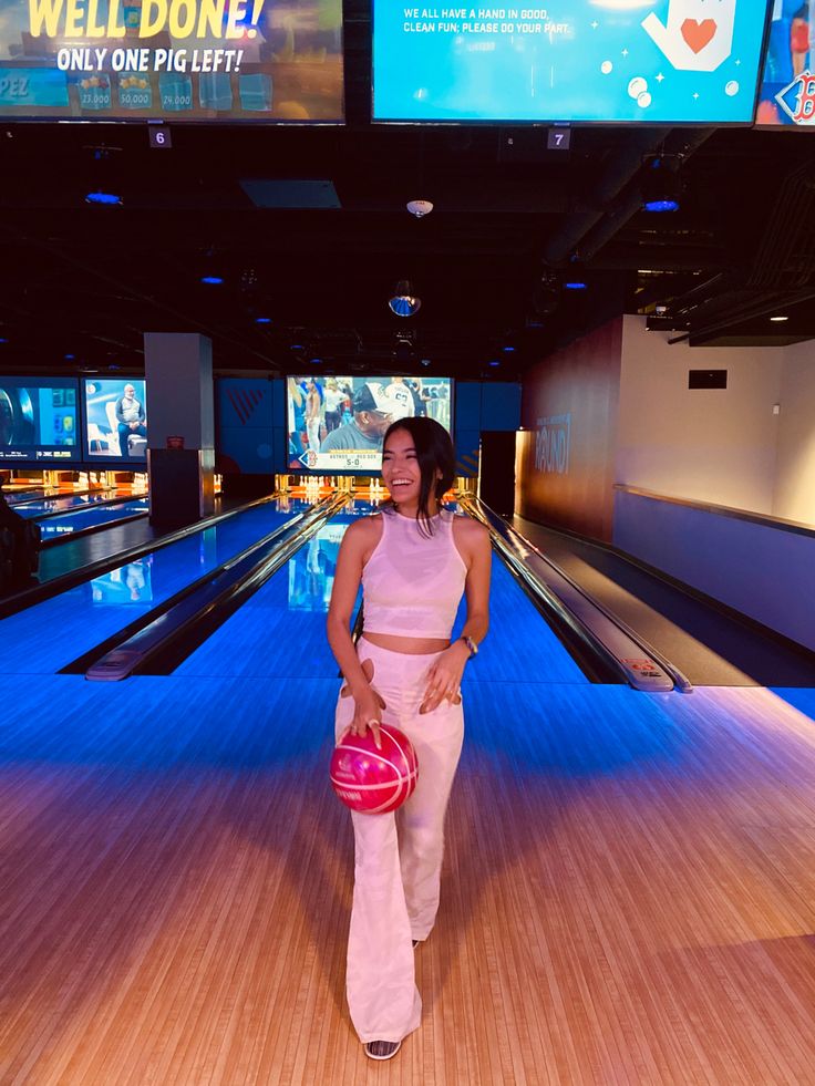 a woman standing in front of bowling lanes