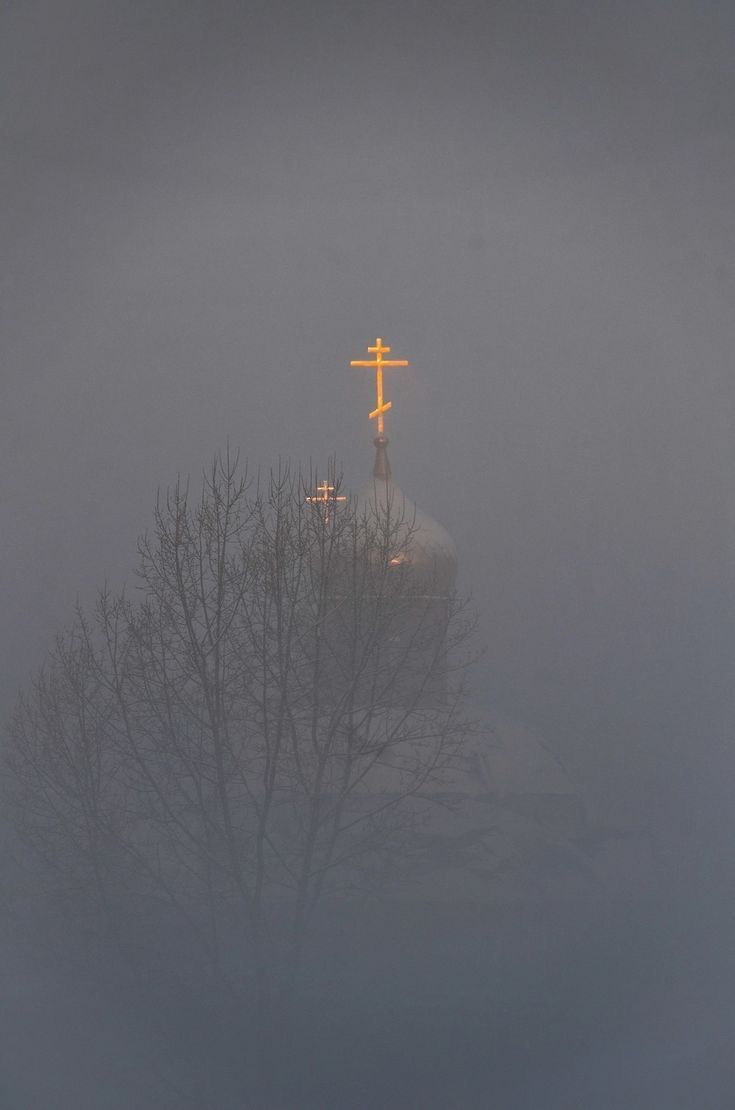 a cross on top of a church in the fog