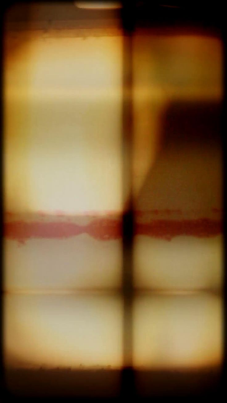 blurry image of an orange and white cake in front of a window pane