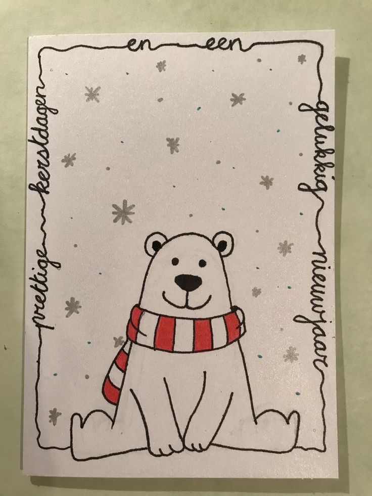 a polar bear wearing a scarf on top of a white paper with snowflakes