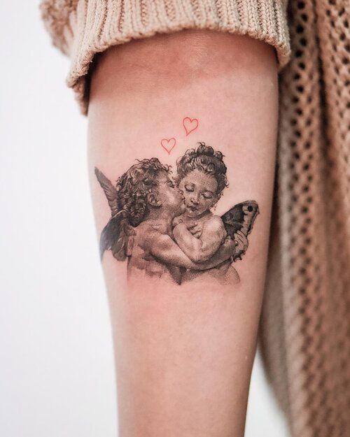 a tattoo with two cherubs on the arm