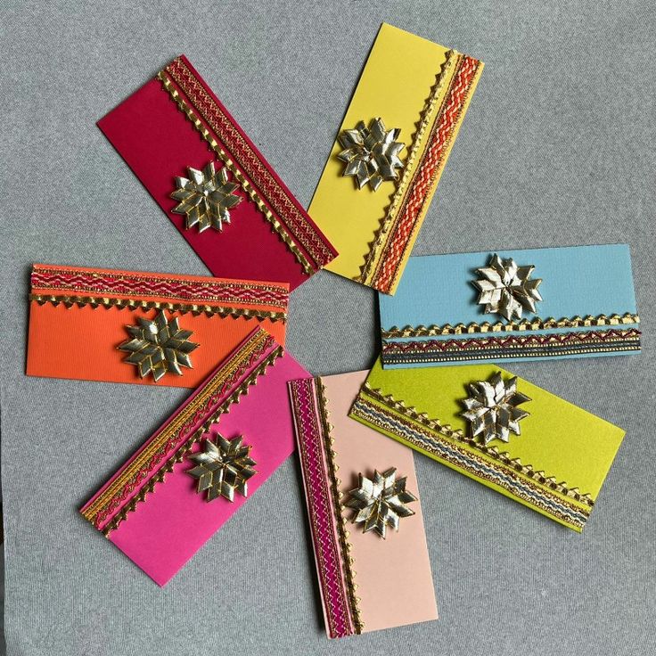 five different colored paper pieces with metal decorations on them