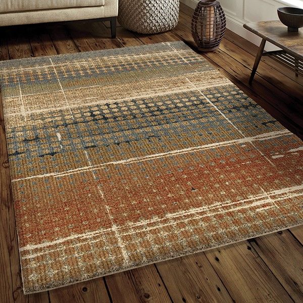 a living room area with wooden floors and rugs on the floor in front of a couch