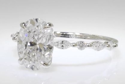 an oval cut diamond ring set in 18k white gold with diamonds around the band