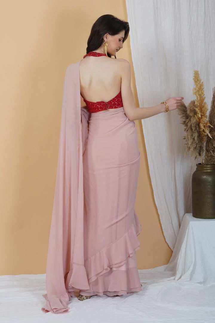 Be it a cocktail party or a day event, put your best foot forward in this stunning frilly saree! With an embellishments red halter neck blouse and a monotone hued blush pink saree, this combination is an eclectic choice for days when you want your look to be chic and sophisticated.Style Blush pink hue Halter neck blouse Frilly Saree Contrasting Combination Georgette fabric Specifications Model height - 5'7" Model wearing - S Glamorous Pink Blouse Piece For Parties, Glamorous Pink Blouse For Festive Occasions, Glamorous Festive Pink Blouse, Glamorous Pink Blouse Piece With Traditional Drape, Elegant Pink Blouse Piece For Party, Elegant Pink Party Blouse Piece, Semi-stitched Pre-draped Saree For Parties, Glamorous Pink Traditional Drape Blouse Piece, Glamorous Pink Saree For Festive Occasion