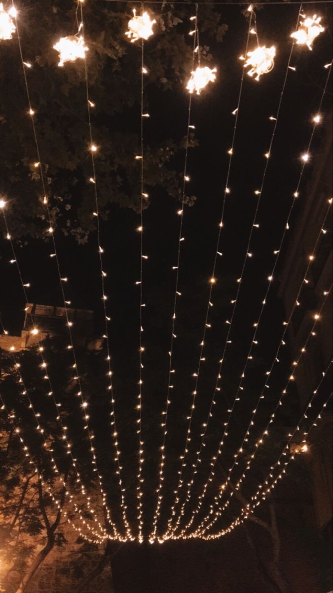 the lights are hanging from the ceiling in front of the building at night with no one around them