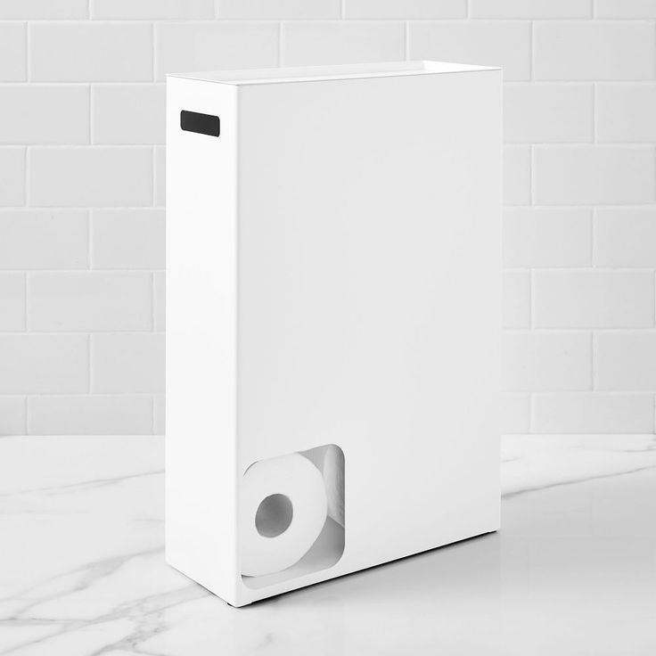 a white box sitting on top of a counter next to a toilet paper dispenser