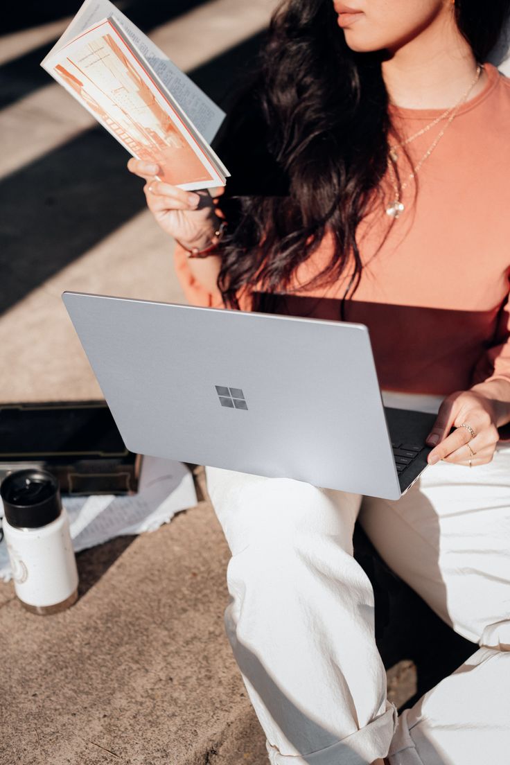 a woman sitting on the ground with her laptop