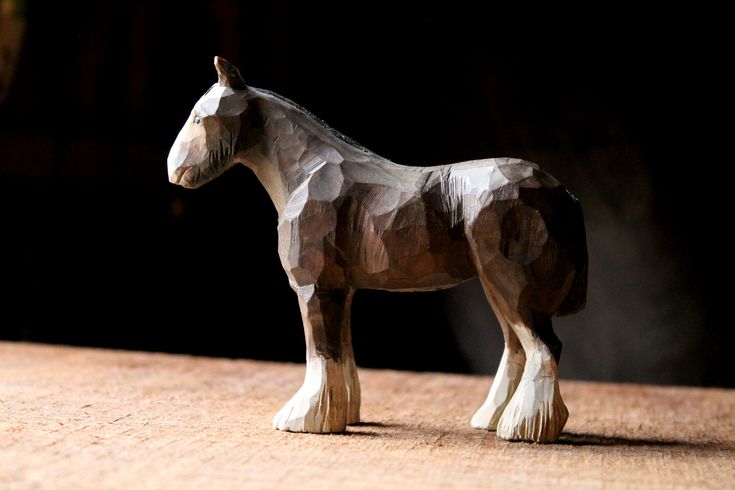 a wooden toy horse standing on top of a table