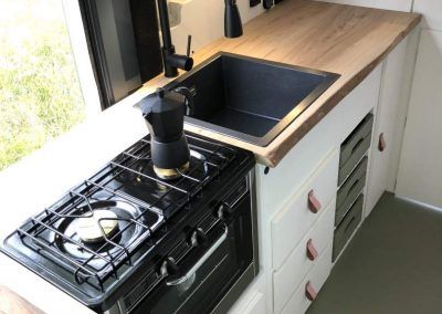 a stove top oven sitting inside of a kitchen next to a sink and countertop