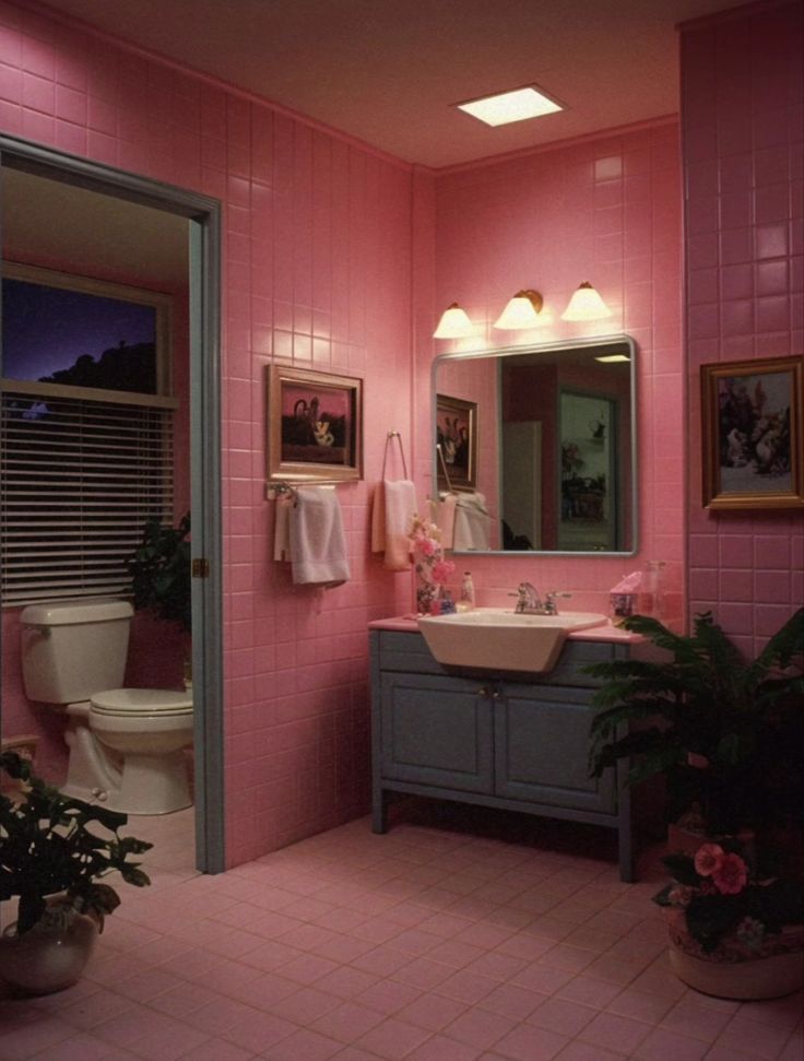 a bathroom with pink walls and tile flooring is pictured in this image, there are potted plants next to the sink