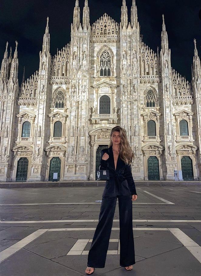 a woman standing in front of a large building