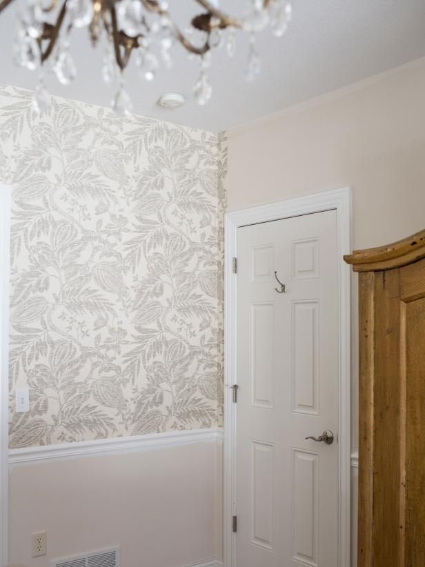 a chandelier hanging from the ceiling in a room with white walls and wallpaper