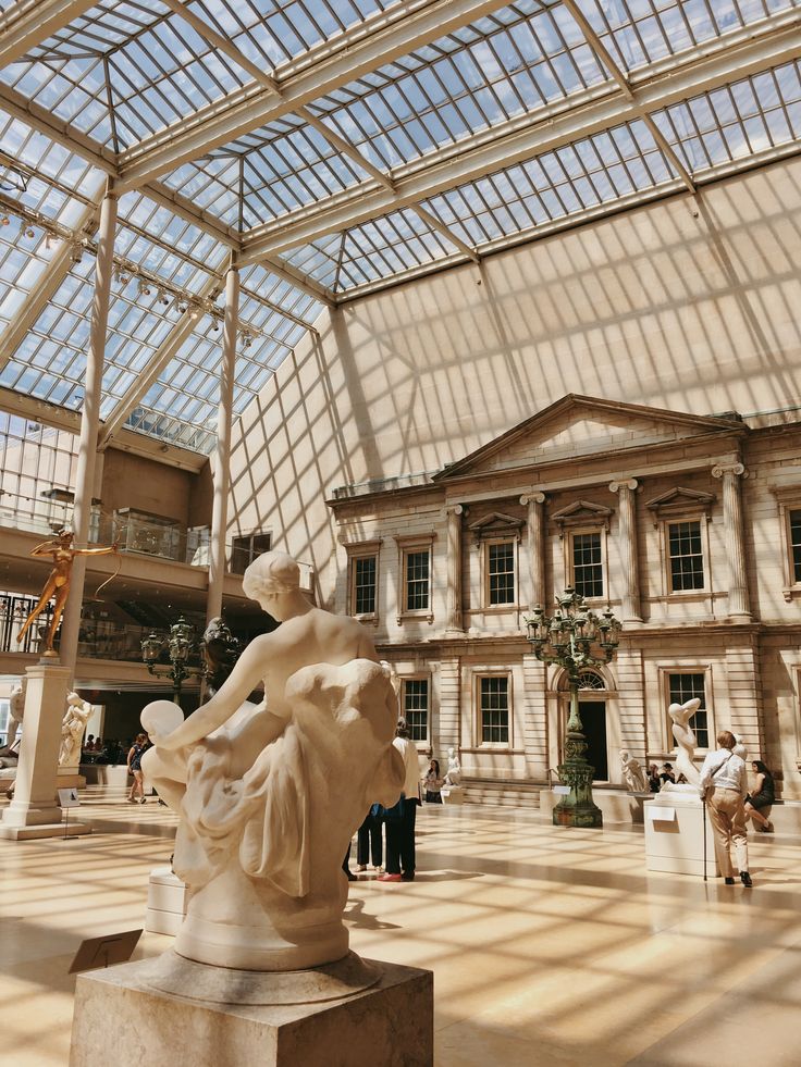 the inside of a building with many statues and people standing around in front of it