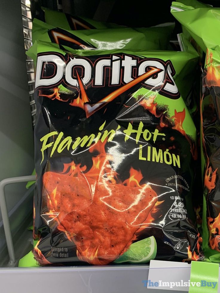 two bags of flaming hot lime chips sitting on a shelf in a grocery store, one is green and the other is orange