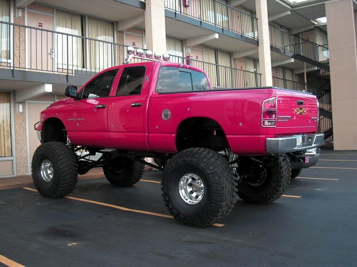 a red pick up truck parked in a parking lot