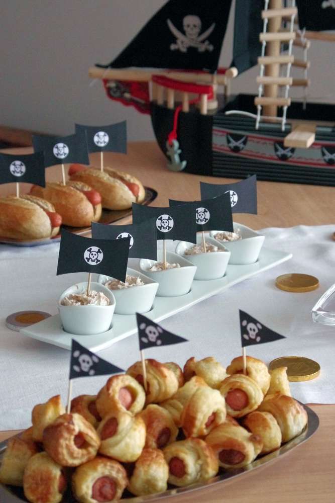 a table topped with lots of food on top of a white tablecloth covered table