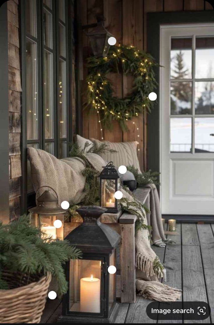 a porch decorated for christmas with lanterns and wreaths