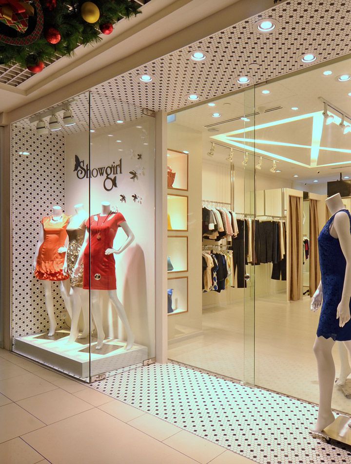 a store window with mannequins and dresses on display