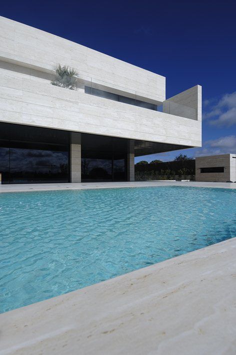 an empty swimming pool in front of a modern building