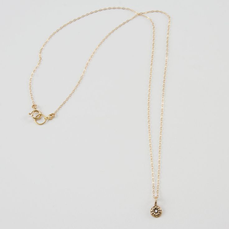 Keep it simple with the DELIA Tiny Flower Pendant Necklace. Small but with a lot of style, accentuate your look with its distinguished elegance. It grabs the attention not just by its shape but also by its charming 14K gold color. This necklace gives you all the reasons to make it a pick of the day. Features: Comfortable Lightweight Elegant and minimal High quality Hand-carved flower-shaped pendant Size & Material: Length: 17" inches Material: 14K gold chain and pendant with an inset of a diamon Everyday 14k Gold Necklaces With Flower Charm, Everyday 14k Gold Necklace With Flower Charm, Elegant Gold Plated Round Birthstone Necklace, Elegant 14k Gold Jewelry With Flower Charm, Classic Gold Jewelry With Flower Charm, Delicate Gold Diamond Necklace With Single Cut Diamonds, Delicate Diamond Necklace With Flower Charm, Delicate Gold Plated Diamond Necklace With Delicate Chain, Elegant Gold Flower Pendant Necklace