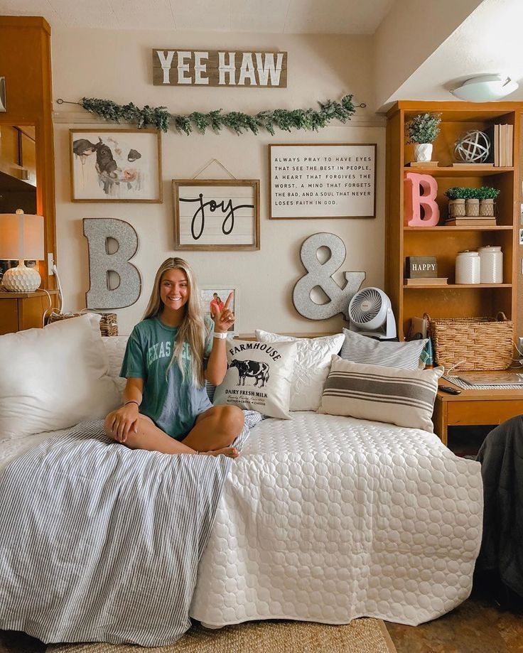 a woman sitting on top of a white bed in a room with lots of decorations