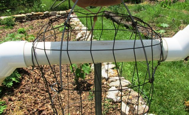 a person is holding onto the top of a white pipe with wires attached to it