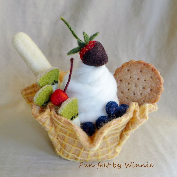 a small stuffed animal is sitting in a waffle cone with fruit and bread on it