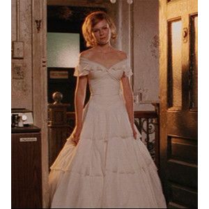 a woman in a white wedding dress is walking down the hall with her hand on her hip