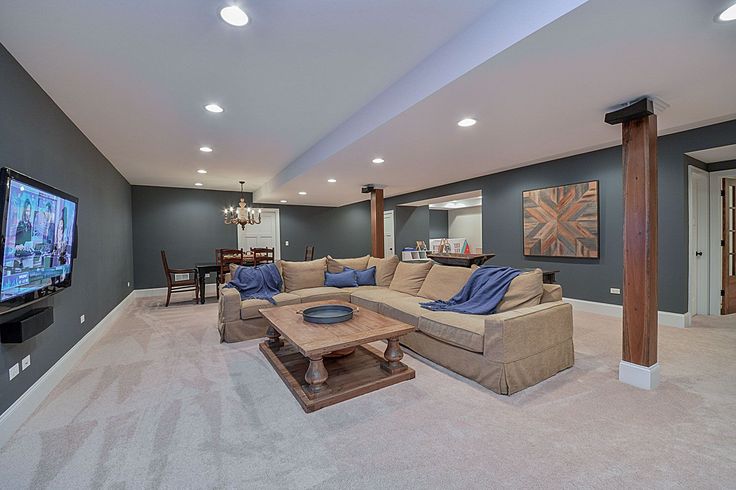 a living room filled with furniture and a flat screen tv mounted to the side of a wall