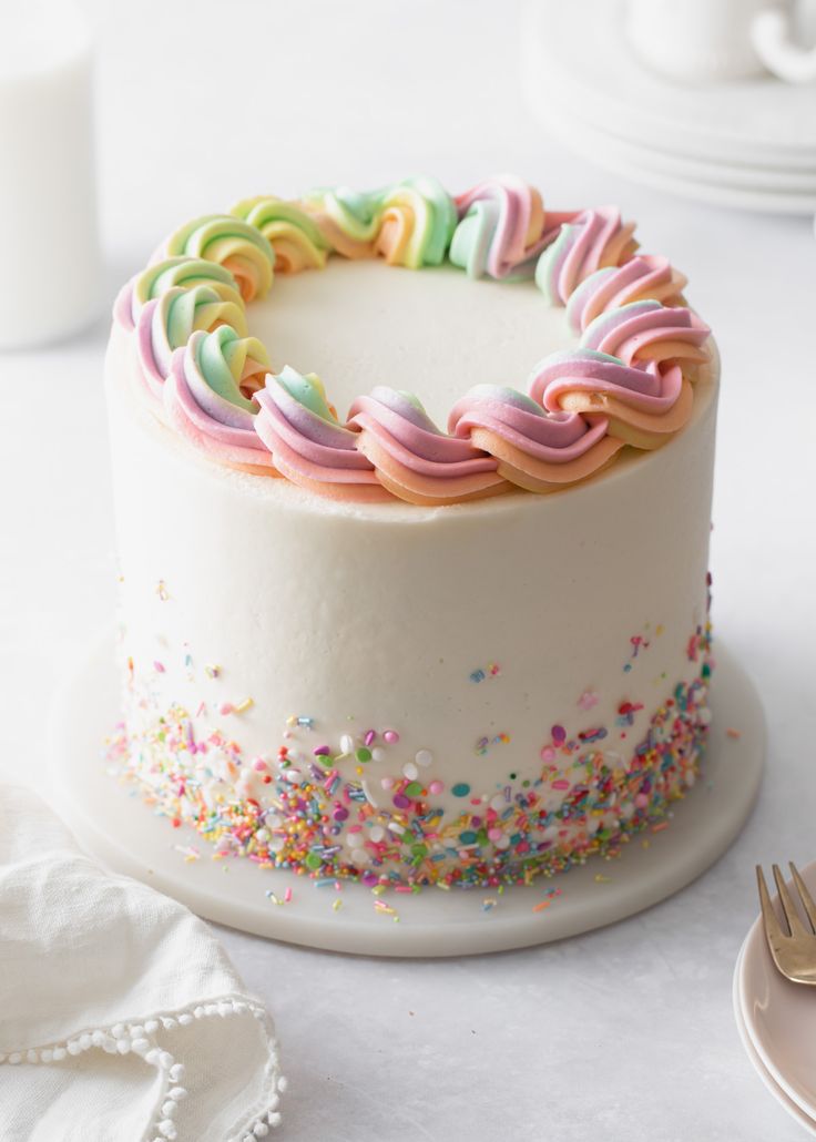 a white cake with sprinkles on it and a fork next to it