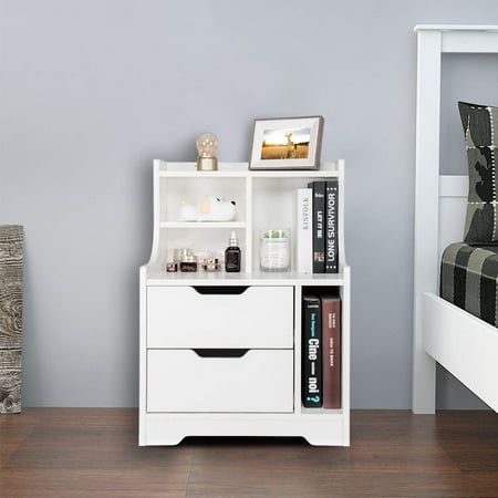 a white book shelf next to a bed in a room with gray walls and wooden floors