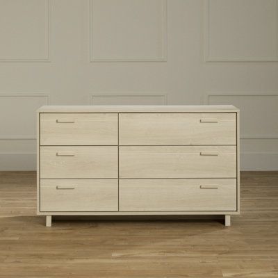 a large white dresser sitting on top of a hard wood floor next to a wall