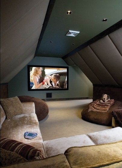 a home theater in the corner of a room with two couches and a large screen