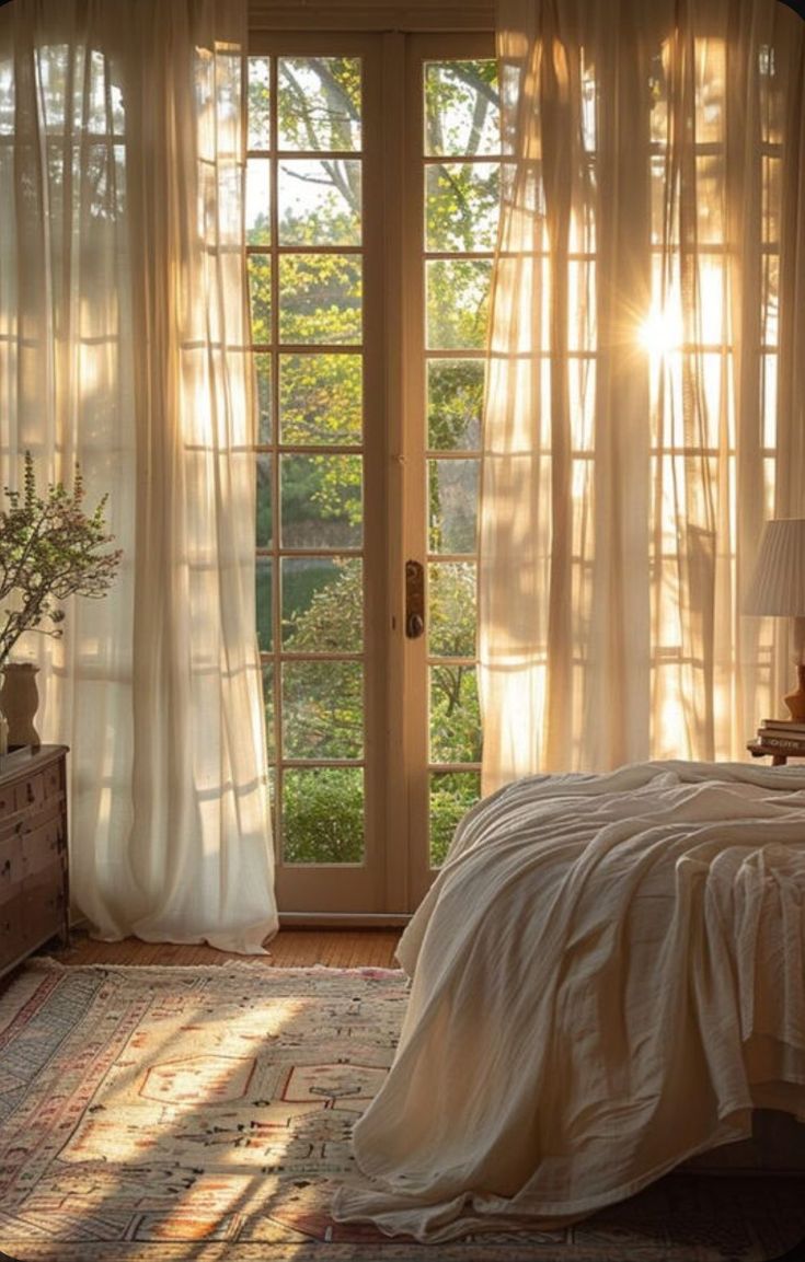 the sun shines through sheer curtains in this bedroom