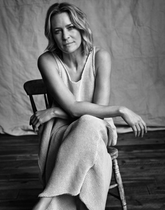 a black and white photo of a woman sitting on a chair