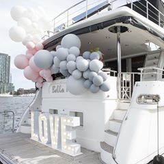 a white boat with balloons attached to it