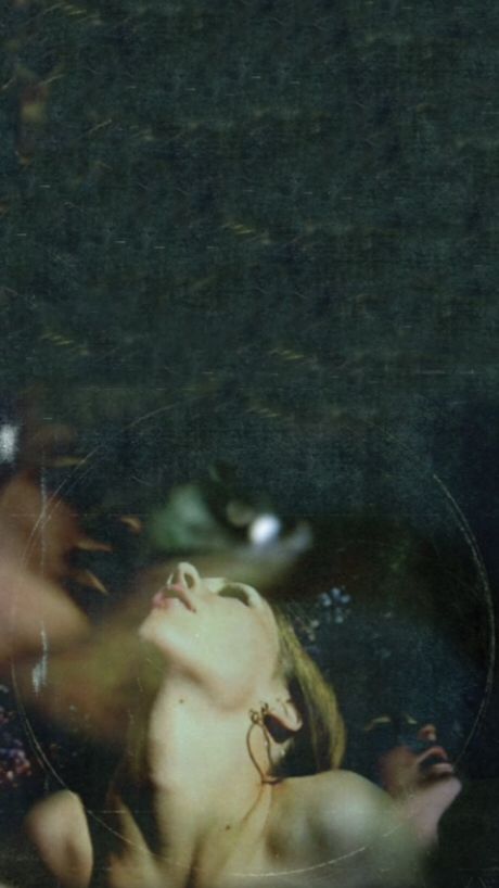 a blurry image of a naked woman laying on the ground with her eyes closed